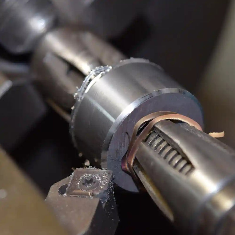 Damastring mit Edelmetalleinlage eingespannt an der Drehmaschine